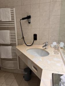 a bathroom with a sink and a shower at Parkhotel Krone Maleck in Emmendingen +16 photos