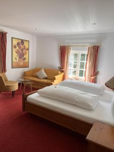 a bedroom with a large bed and a couch at Parkhotel Krone Maleck in Emmendingen