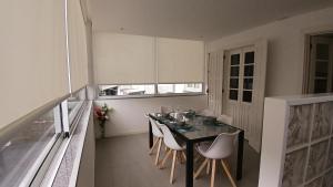 a dining room with a table and white chairs at 4-As Andar-Moradia Muralhas in Guimarães