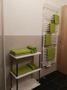 a bathroom with green towels and a shower at Ferienwohnung Mair in Umhausen