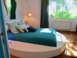 a bed in a room with a large window at La Clotière in La Guerche-de-Bretagne