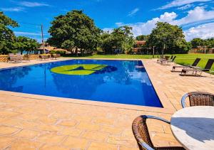 a swimming pool with a table and chairs at Hotel Cumuruxatiba in Cumuruxatiba +13 photos