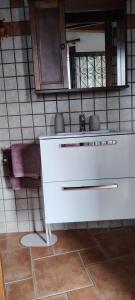 a bathroom with a white sink and a mirror at La Casetta 23 in Perledo