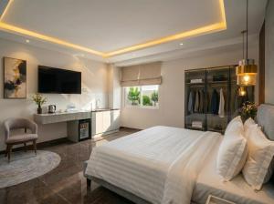 a bedroom with a large white bed and a desk at Soléa Boutique Hotel & Spa By Sol in Ho Chi Minh City
