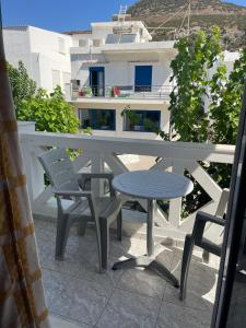 a table and chairs on a balcony with a view of a building at studios costareli in Vrachonisída Diapóri