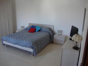 um quarto com uma cama com duas almofadas em La Villa Bianca em Lama