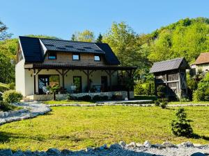 a house with a gambrel roof and a yard at Green Hills - Holiday Home & Events in Kamenica
