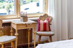 a bed room with a table and a chair with a pillow at Försterhaus Wohnung Obergeschoss in Egg