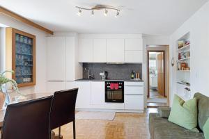 a kitchen with white cabinets and a table at Försterhaus Wohnung Obergeschoss in Egg