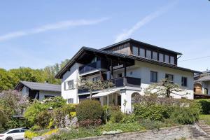 a white house with a black roof at Försterhaus Wohnung Obergeschoss in Egg