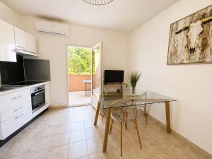 a dining room with a glass table in a kitchen at Charmant 3 pièces avec terrasse, vue mer et parking à Vence in Vence