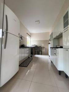 a large kitchen with white appliances and a long hallway at Rancho Rocha in Buritama