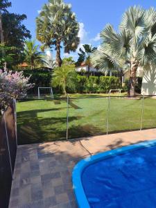 a swimming pool in a yard with palm trees at Rancho Rocha in Buritama +6 photos