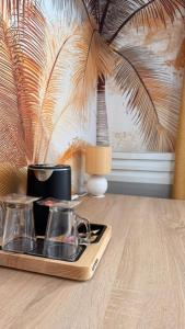 a tray with two cups on a wooden table at Cit'Hôtel Le Quai 9 in Challans