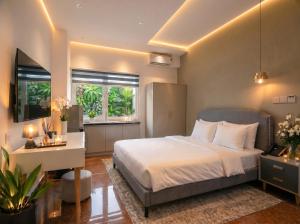 a bedroom with a bed and a desk and windows at Soléa Boutique Hotel & Spa By Sol in Ho Chi Minh City +9 photos