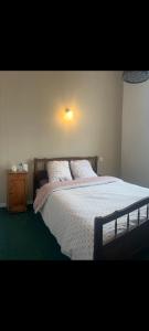 a bedroom with a bed with a white comforter at Hôtel Restaurant Le Vieux Logis in Aignan
