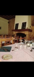 a table with a white table cloth and glasses on it at Hôtel Restaurant Le Vieux Logis in Aignan