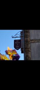 a sign for a restaurant with umbrellas in front of a building at Hôtel Restaurant Le Vieux Logis in Aignan +4 photos