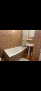 a bathroom with a tub and a toilet and a sink at Hôtel Restaurant Le Vieux Logis in Aignan