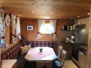 a dining room with a table and a kitchen at Hüttenzeit almhütte sölden in Sölden