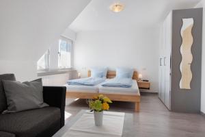 a bedroom with a bed and a couch at Seetraum Berger in Hagnau