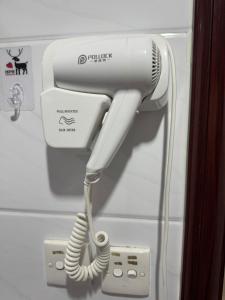 a white blow dryer is attached to a wall at Reliance Block C 12f in Hong Kong +32 photos