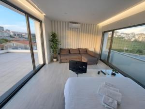 a bedroom with a bed and a couch on a balcony at Figueira Beach Apartment in Buarcos