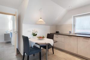 a kitchen and dining room with a table and chairs at Seetraum Berger in Hagnau