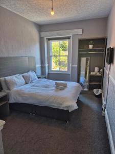 a bedroom with a large bed and a window at The Old Victoria in Penrith
