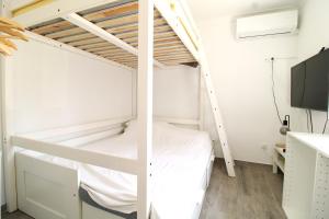 a bunk bed in a small room with a tv at Little Paradise in Castro Marim