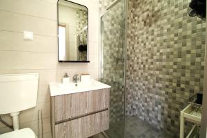 a bathroom with a sink and a glass shower at Little Paradise in Castro Marim