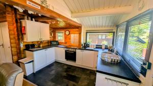 a kitchen with white cabinets and a black counter top at Lunalodge in Trawsfynydd