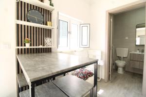 a kitchen with a table and a clock on a wall at Little Paradise in Castro Marim