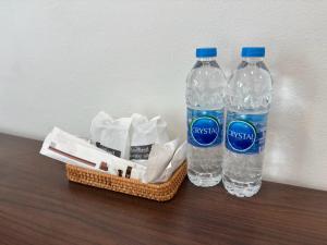 two bottles of water and a basket on a table at Laloon Guesthouse in Hat Yai