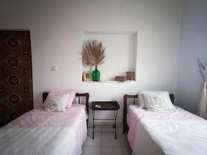 a room with two beds and a table and a mirror at Casa Tota in Assomada