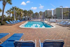 a swimming pool with blue lounge chairs around it at Pinnacle Port, C2-603 in Panama City Beach