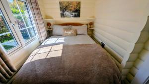 a bed in a small room with a window at Lunalodge in Trawsfynydd +13 photos