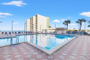 a swimming pool in front of a building with palm trees at Pinnacle Port, C2-603 in Panama City Beach