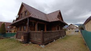 a large wooden house with a wooden fence around it at Zrub u Zuzany in Lazy pod Makytou