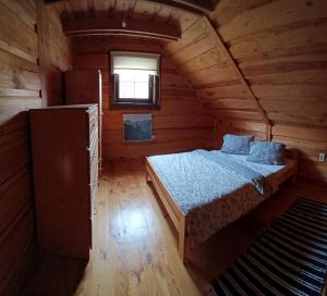 a bedroom with a bed in a wooden cabin at Zrub u Zuzany in Lazy pod Makytou