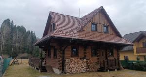 a log house with a roof on top of logs at Zrub u Zuzany in Lazy pod Makytou +5 photos