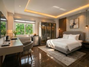 a hotel room with a bed and a desk and a desk at Soléa Boutique Hotel & Spa By Sol in Ho Chi Minh City
