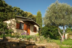 une maison avec un mur en pierre et des arbres dans l'établissement La Cerca Del Alcornoque, à Casas de Belvis
