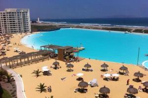 una gran piscina en una playa con sombrillas en Laguna Del Mar II, en La Serena