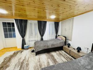a bedroom with two beds and a wooden ceiling at The House 39 in Sheki