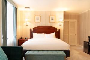 a bedroom with a large bed and a chair at Hotel Stanford in New York