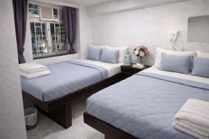 a hotel room with two beds and a window at Reliance Block C 12f in Hong Kong