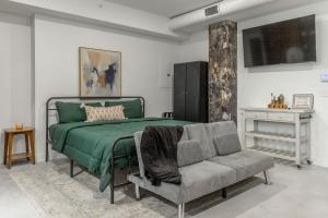 a bedroom with a green bed and a chair at Park Hotel Studio Suite 511 in Chattanooga
