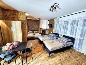 a room with two beds and a table and chairs at NOCLEGI POD STODOŁĄ in Krakow