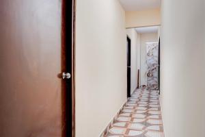 a hallway with a tile floor and an open door at Hotel O Shivay Inn Ayodhaya Bypass Road in Bhopal